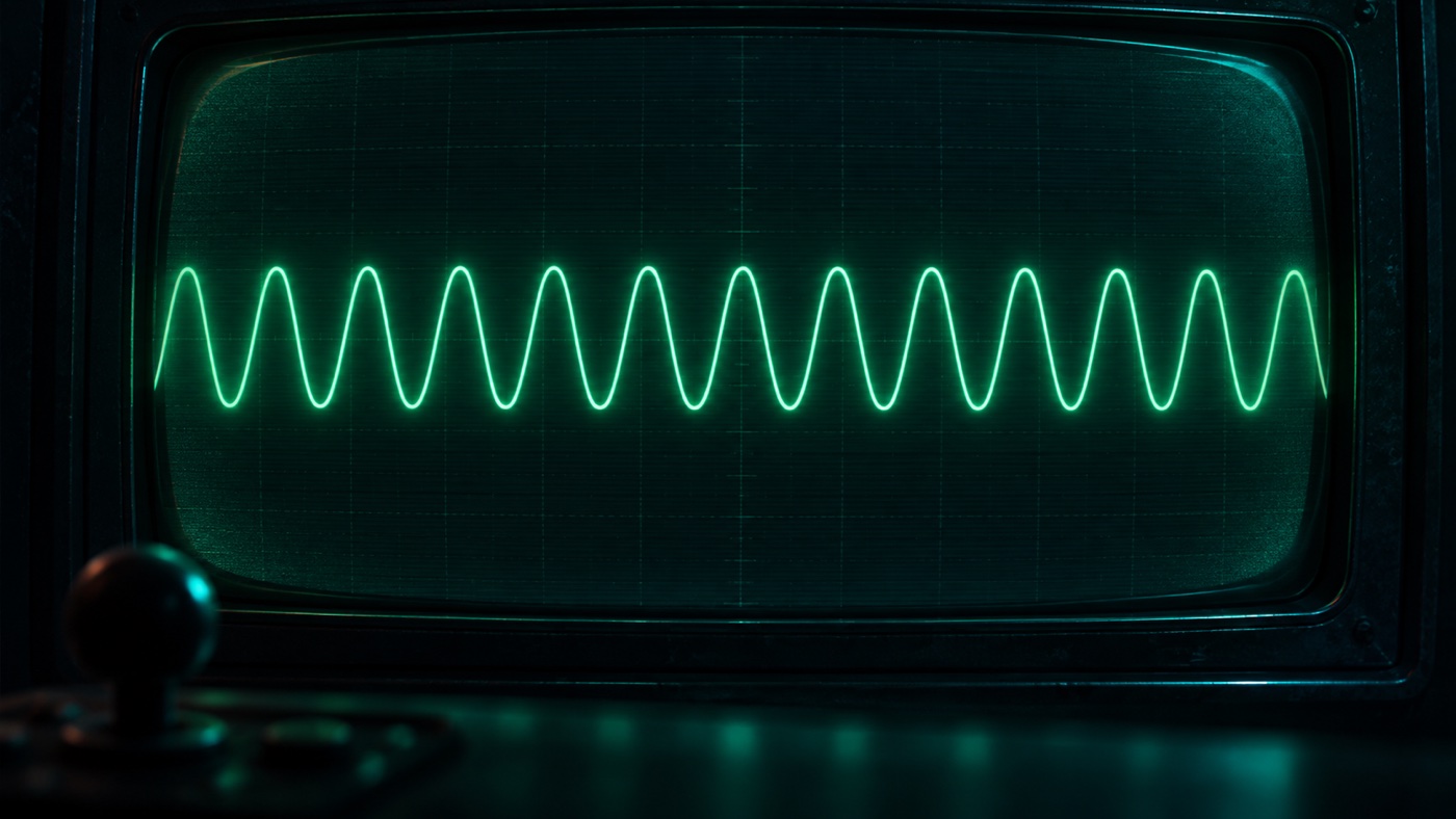 A smooth, evenly repeating green oscilloscope waveform on a CRT, a joystick silhouette in the foreground